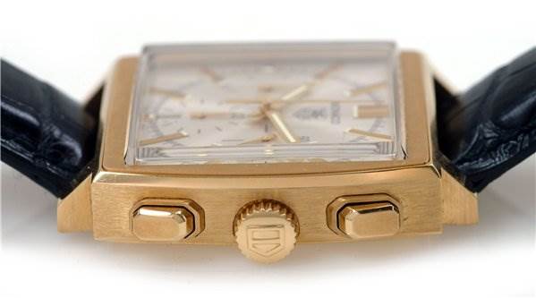 The image shows a side view of the Tag Heuer Monaco CW5140 Men's Yellow Gold Silver Dial CW5140 Men's Yellow Gold Silver Dial watch, highlighting its gold case, crown, and pushers.