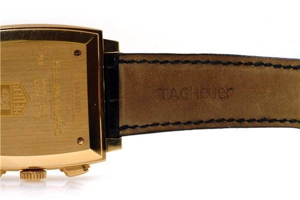 The image shows the back and partial strap of a Tag Heuer Monaco CW5140 Men's Yellow Gold Silver Dial CW5140 Men's Yellow Gold Silver Dial model watch, highlighting the engraved case back and leather strap.
