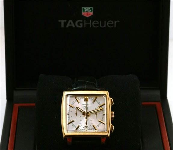 The image shows a front view of the Tag Heuer Monaco CW5140 Men's Yellow Gold Silver Dial CW5140 Men's Yellow Gold Silver Dial watch, displaying its face, case, and pushers, in its branded box.