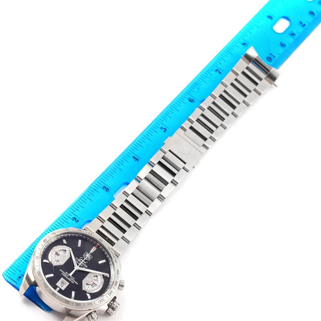 The image shows a Tag Heuer Carrera CAV511A Men's Stainless Steel Black Dial CAV511A Men's Stainless Steel Black Dial watch laid flat with its metal bracelet next to a blue ruler for scale.