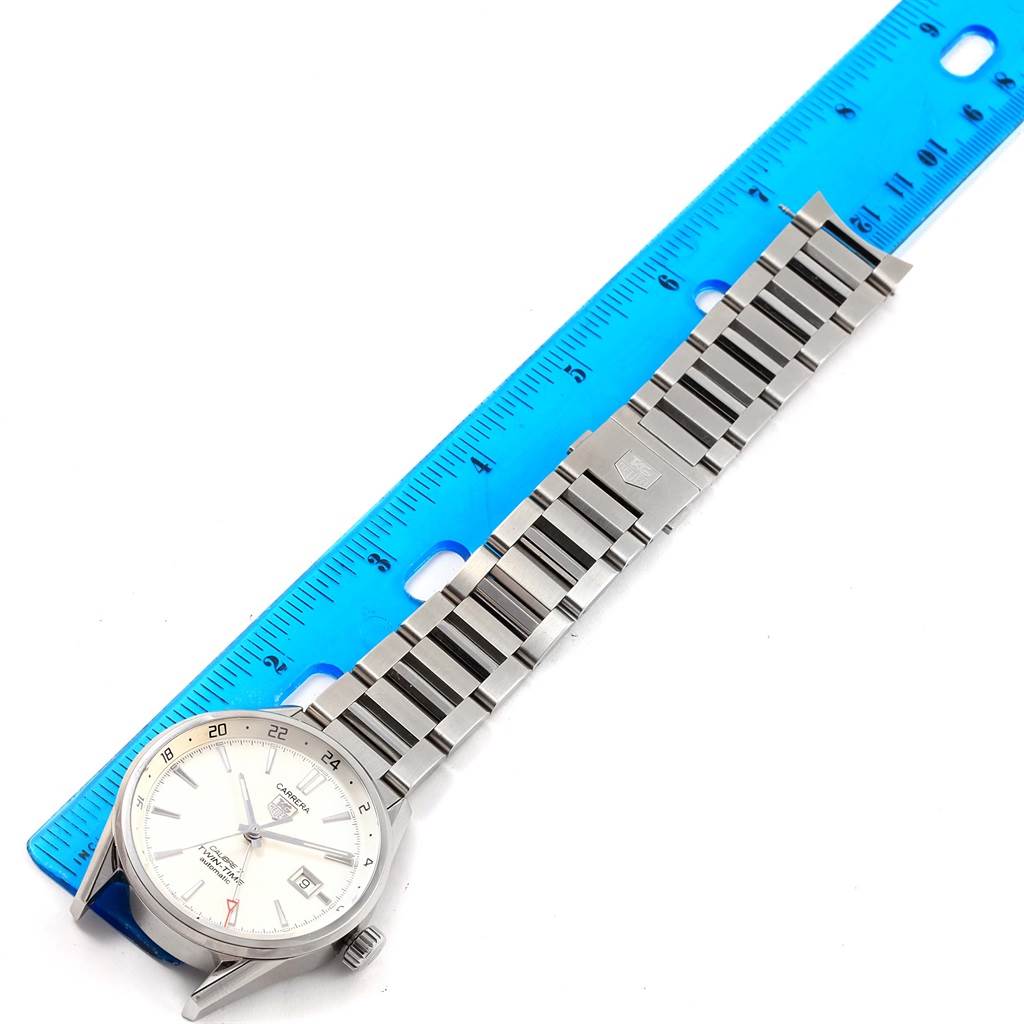 The Tag Heuer Carrera WAR2011.BA0723 Men's Stainless Steel Silver Dial WAR2011.BA0723 Men's Stainless Steel Silver Dial model watch is shown from a top-down view with its stainless steel band alongside a blue ruler.