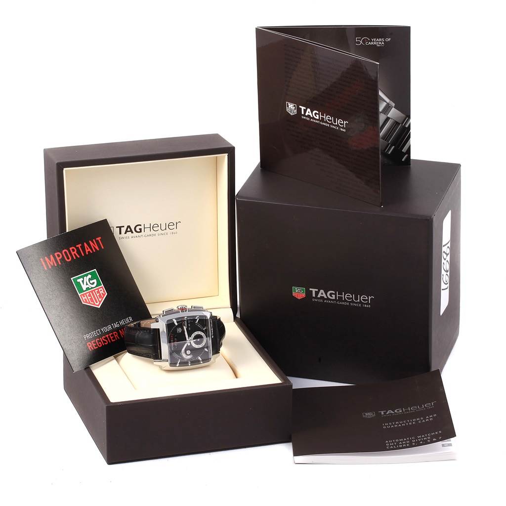 The image shows a Tag Heuer Monaco CAL2110.FC6257 Men's Stainless Steel Black Dial CAL2110.FC6257 Men's Stainless Steel Black Dial watch in its box, alongside its packaging and manuals.