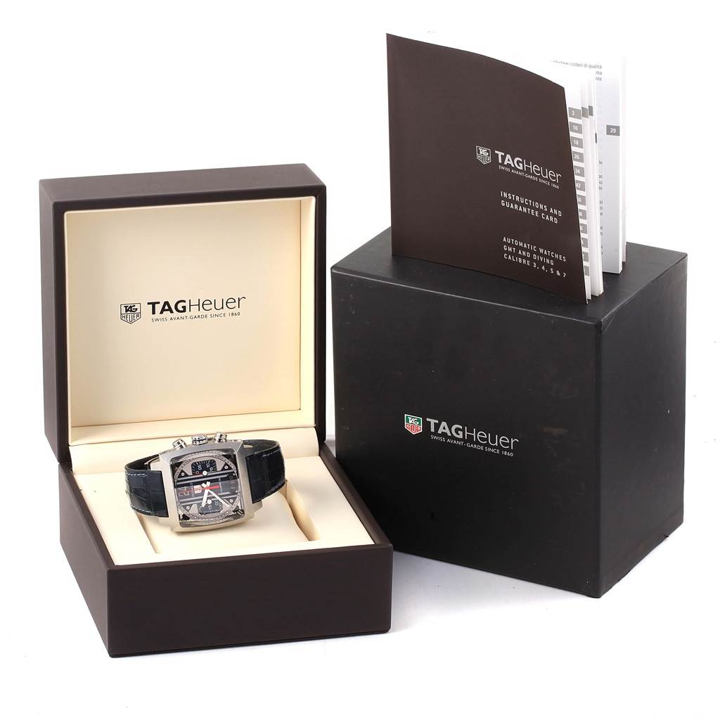 The image shows a Tag Heuer Monaco CAL5111.FC6299 Men's Stainless Steel Blue Dial CAL5111.FC6299 Men's Stainless Steel Blue Dial watch in its open box, along with an instruction manual and outer packaging.