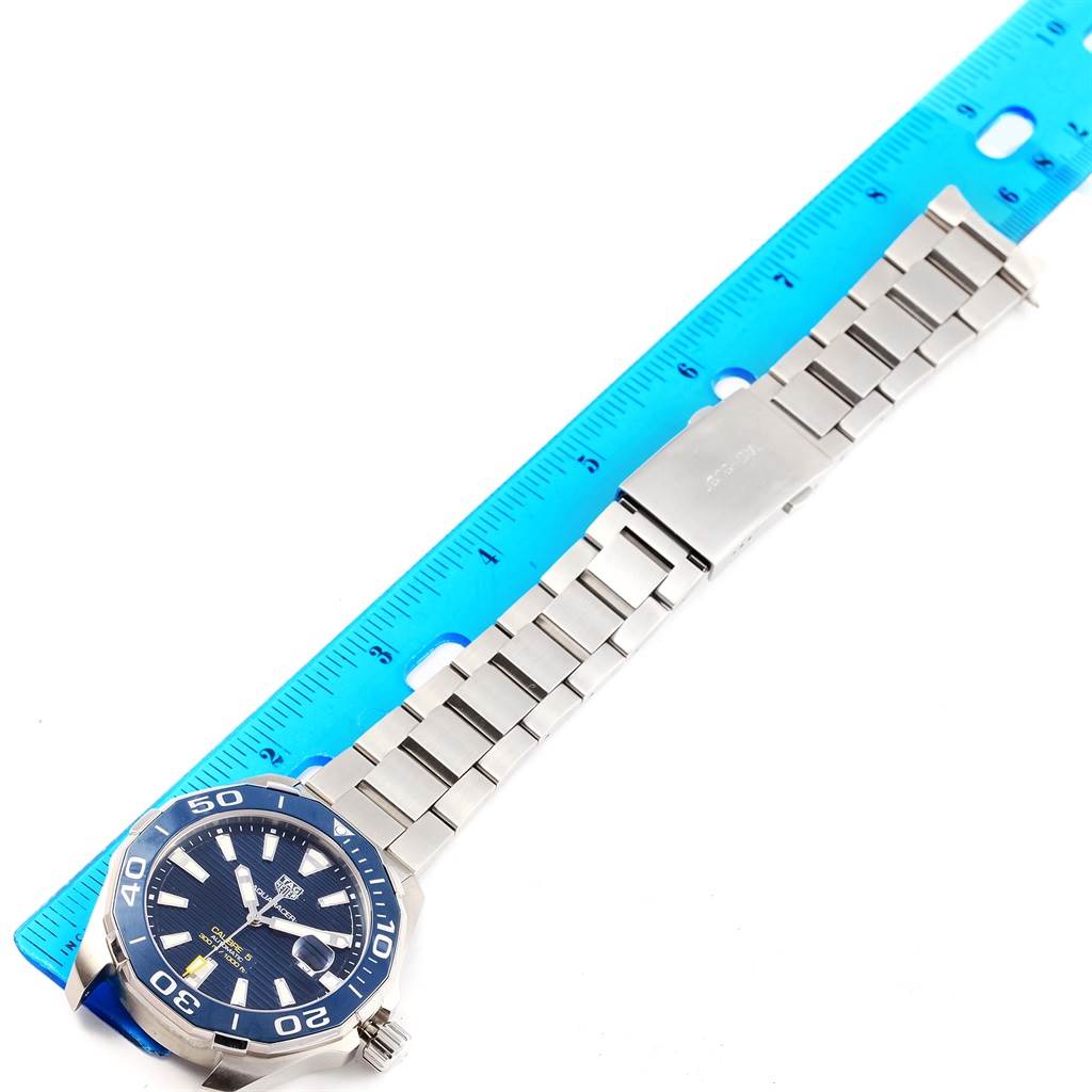 The image shows a Tag Heuer Aquaracer WAY201B Men's Stainless Steel Blue Dial WAY201B Men's Stainless Steel Blue Dial watch laid flat next to a ruler, displaying the watch face and stainless steel bracelet.