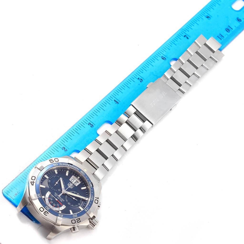 The image shows a Tag Heuer Aquaracer CAF101C.BA0821 Men's Stainless Steel Blue Dial CAF101C.BA0821 Men's Stainless Steel Blue Dial watch, lying flat next to a ruler, displaying its face and stainless steel band.