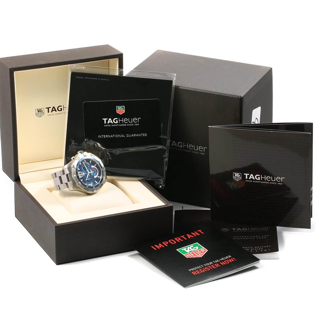 The image shows the Tag Heuer Aquaracer CAF101C.BA0821 Men's Stainless Steel Blue Dial CAF101C.BA0821 Men's Stainless Steel Blue Dial watch, its box, international guarantee card, and manuals from a front angle.
