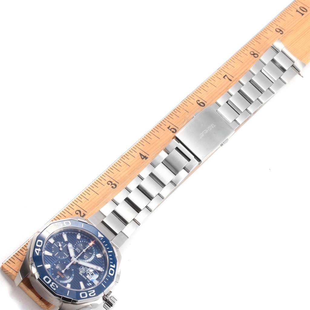 This image shows a Tag Heuer Aquaracer CAY211B.BA0927 Men
s Stainless Steel Blue Dial CAY211B.BA0927 Men
s Stainless Steel Blue Dial watch lying flat, with its metal bracelet extended alongside a ruler.