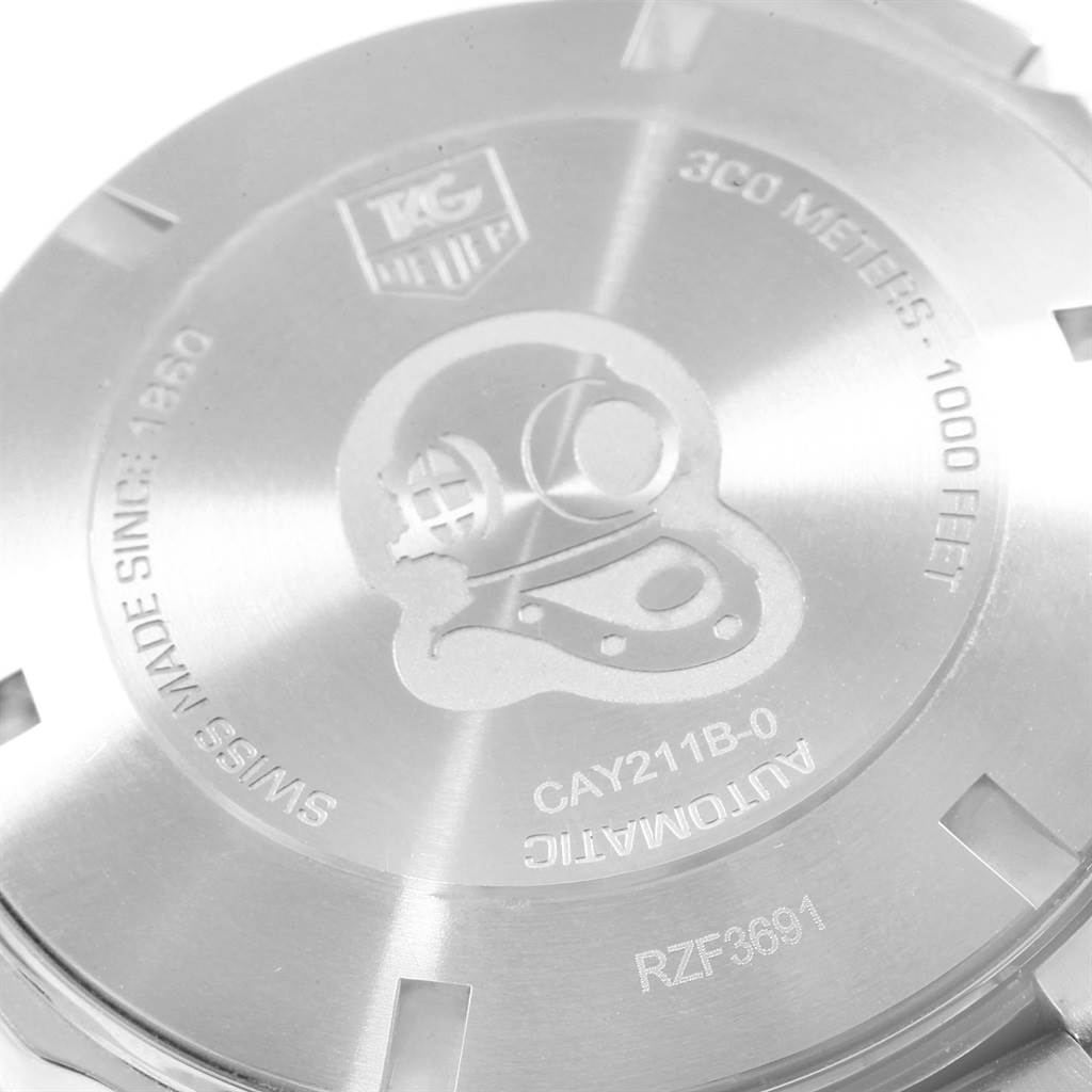 The image shows the back case of an Aquaracer model watch by Tag Heuer, featuring an engraved design and specifications.