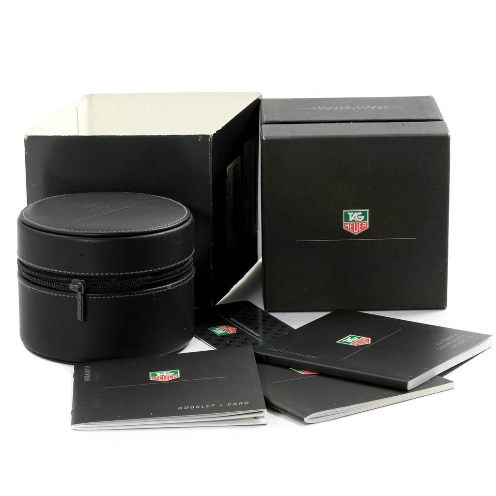 The image shows the packaging and documentation for a Tag Heuer Monaco TAG HEUER Men's Stainless Steel Blue Dial TAG HEUER Men's Stainless Steel Blue Dial watch, including a black box, a zippered leather case, and booklets.