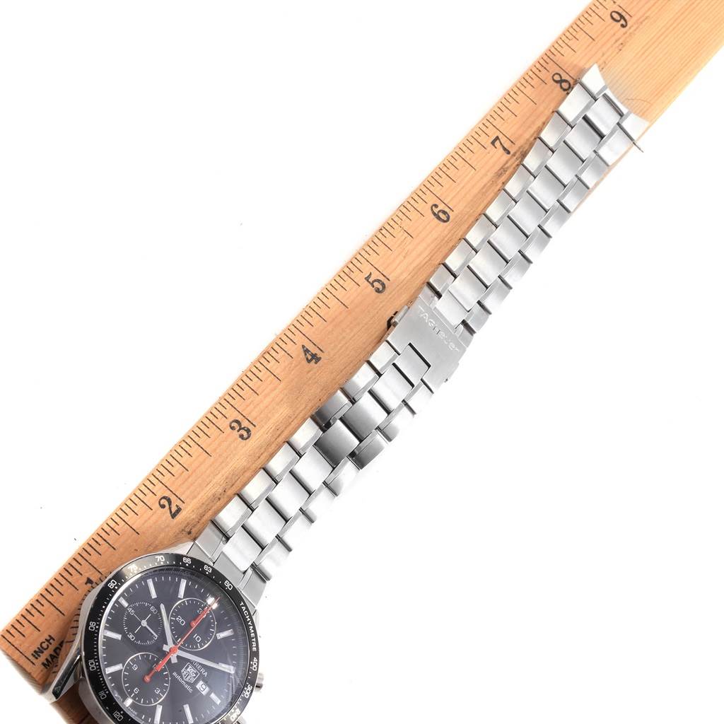 The image shows a Tag Heuer Carrera CV2014.BA0794 Men's Stainless Steel Black Dial CV2014.BA0794 Men's Stainless Steel Black Dial watch with its stainless steel bracelet partially extended alongside a ruler.