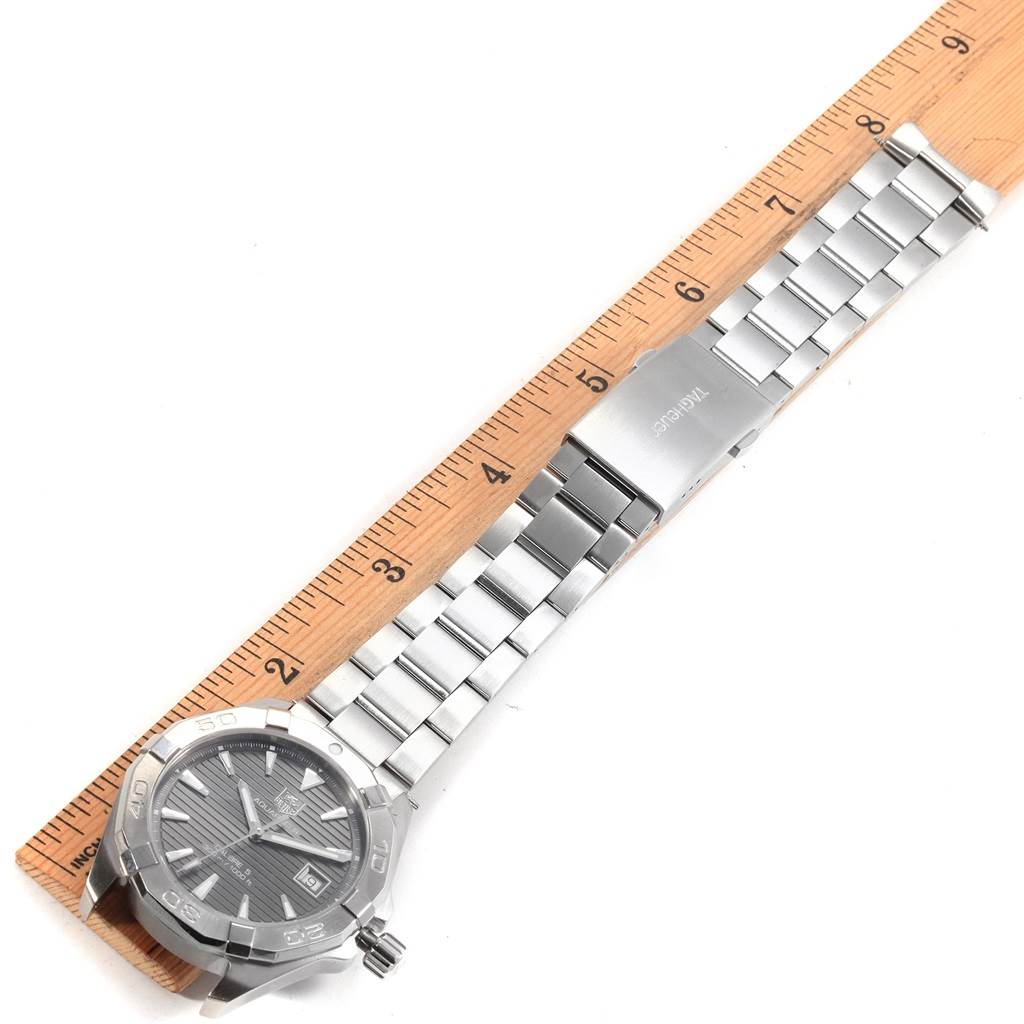 This image shows a Tag Heuer Aquaracer WAY2113.BA0928 Men's Stainless Steel Black Dial WAY2113.BA0928 Men's Stainless Steel Black Dial watch laid flat, face up, with its metal bracelet band aligned with a ruler.