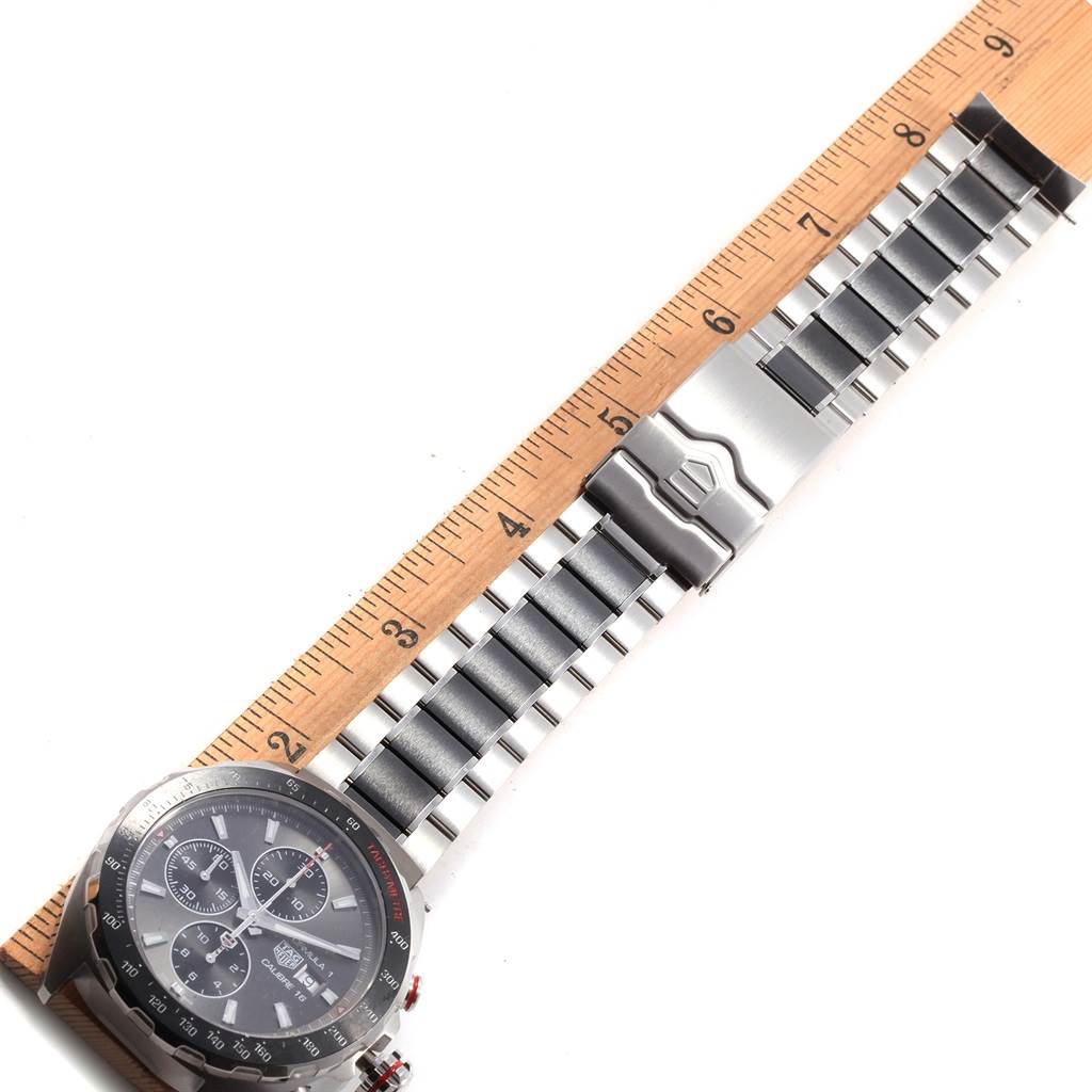 The image shows a top view of a Tag Heuer Formula 1 CAZ2012.BA0970 Men's Stainless Steel Grey Dial CAZ2012.BA0970 Men's Stainless Steel Grey Dial watch, including the dial, bezel, and metal bracelet next to a ruler.