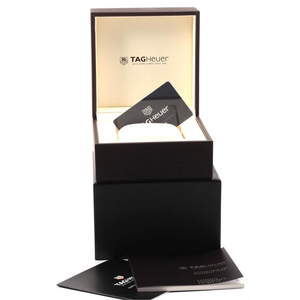 The image shows the packaging and accessories of a Tag Heuer Monaco CAW2111 Men's Stainless Steel Blue Dial CAW2111 Men's Stainless Steel Blue Dial watch, including a box and warranty card.