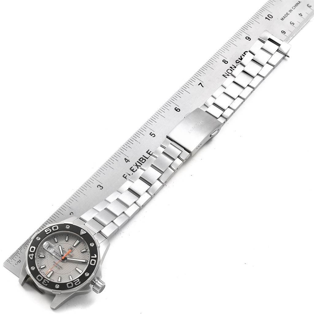The image shows a top view of a Tag Heuer Aquaracer WAJ1111.BA0870 Men's Stainless Steel Grey Dial WAJ1111.BA0870 Men's Stainless Steel Grey Dial watch, including the face, bezel, bracelet, and clasp, placed alongside a ruler.