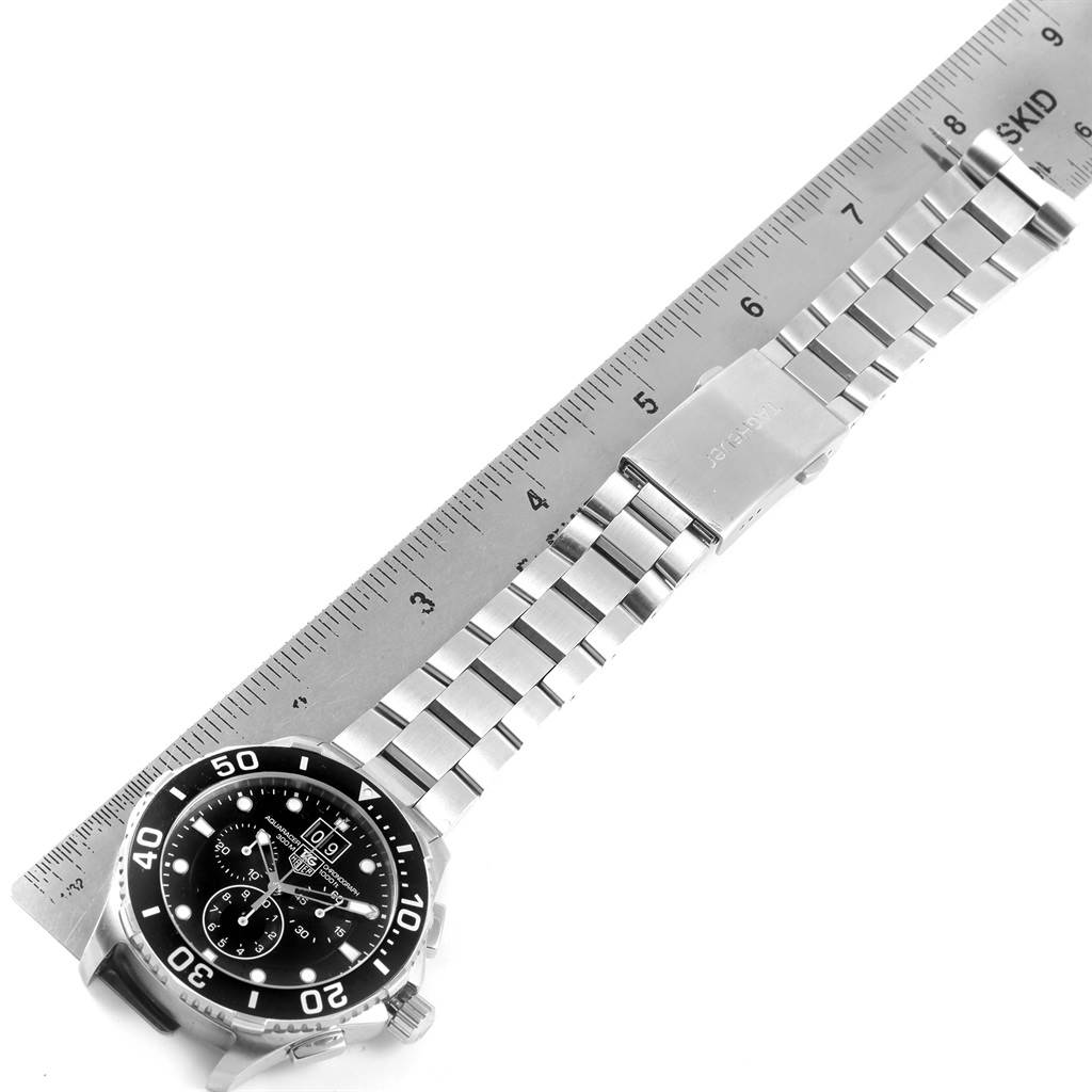 The image shows a top-down view of a Tag Heuer Aquaracer CAN1010.BA0821 Men's Stainless Steel Black Dial CAN1010.BA0821 Men's Stainless Steel Black Dial watch with a ruler measuring its stainless steel bracelet.