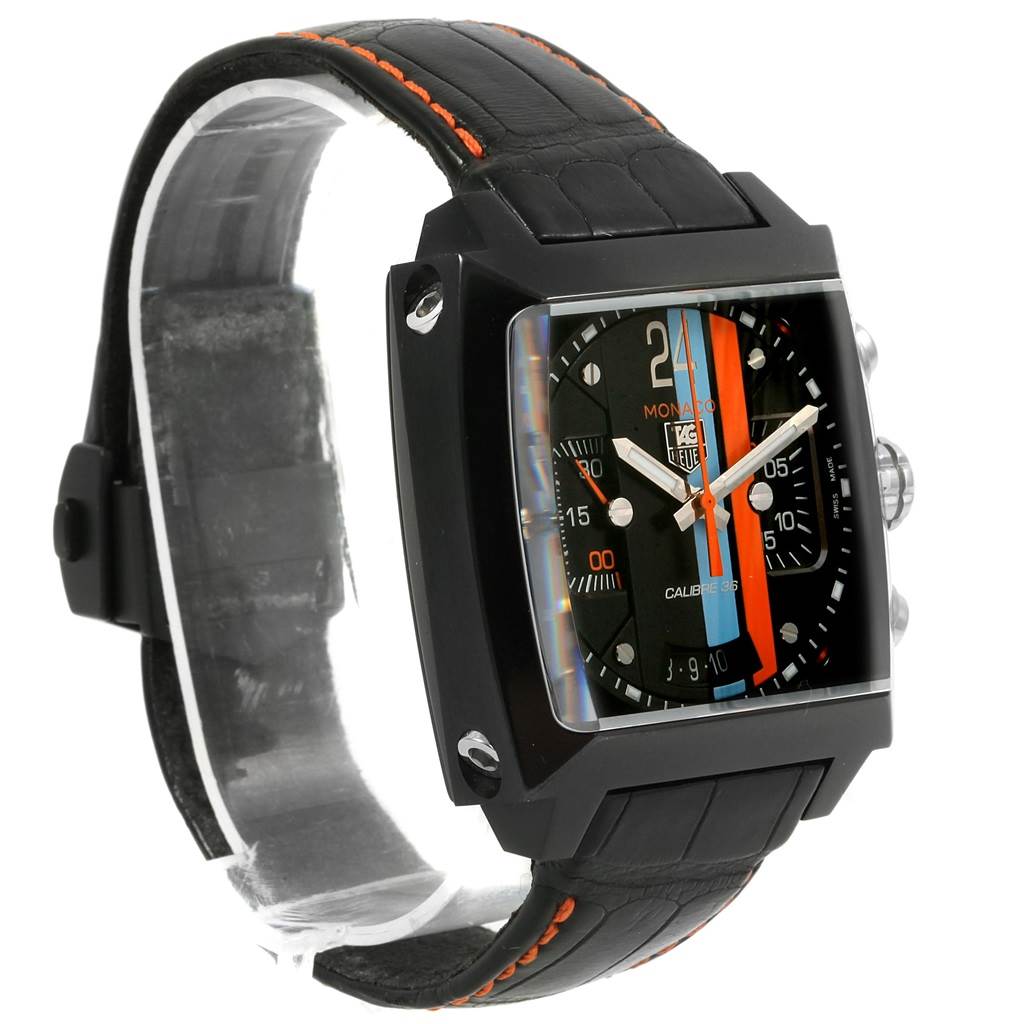 The Tag Heuer Monaco Limited Edition watch is shown at a slight angle, revealing its square face, black case, and black leather strap with orange stitching.