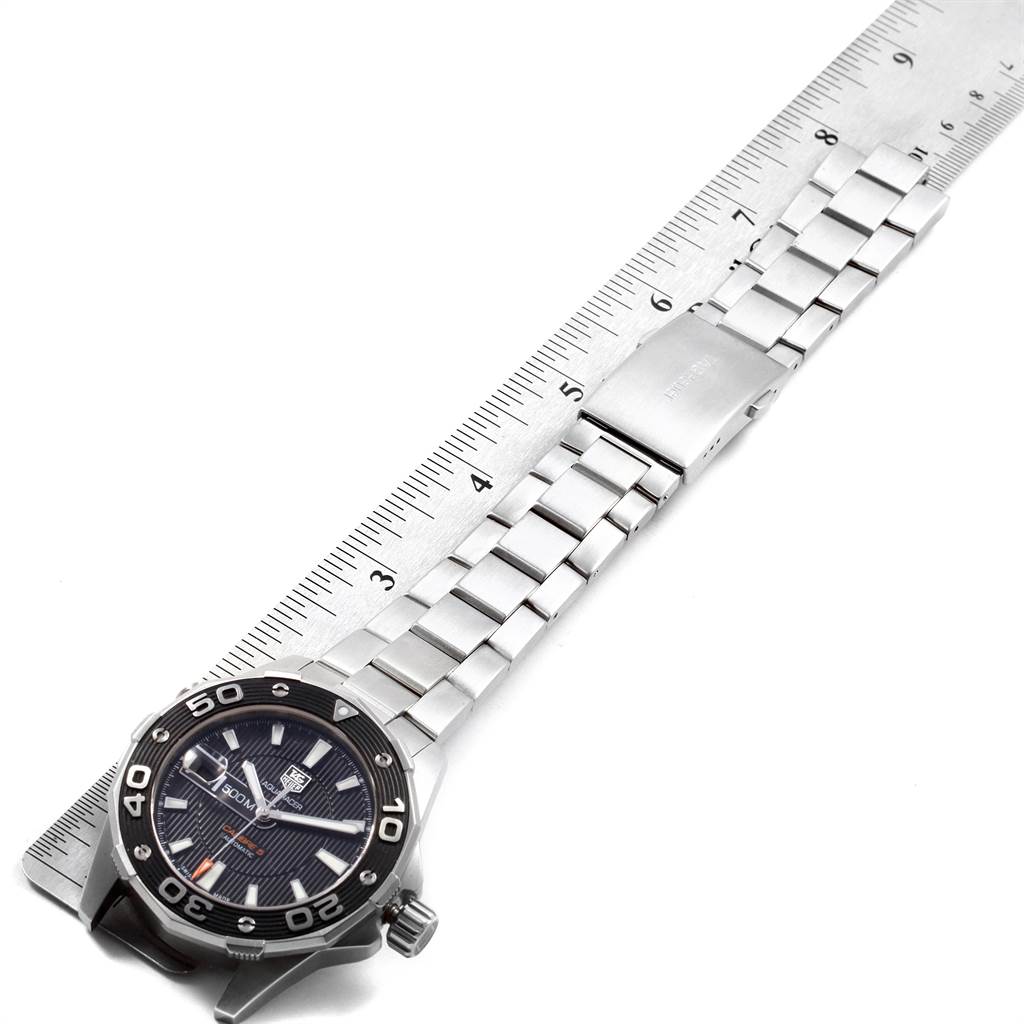 The image shows a Tag Heuer Aquaracer WAJ2110.BA0870 Men
s Stainless Steel Black Dial WAJ2110.BA0870 Men
s Stainless Steel Black Dial watch laid flat next to a ruler, displaying the full watch band and face from a top-down angle.