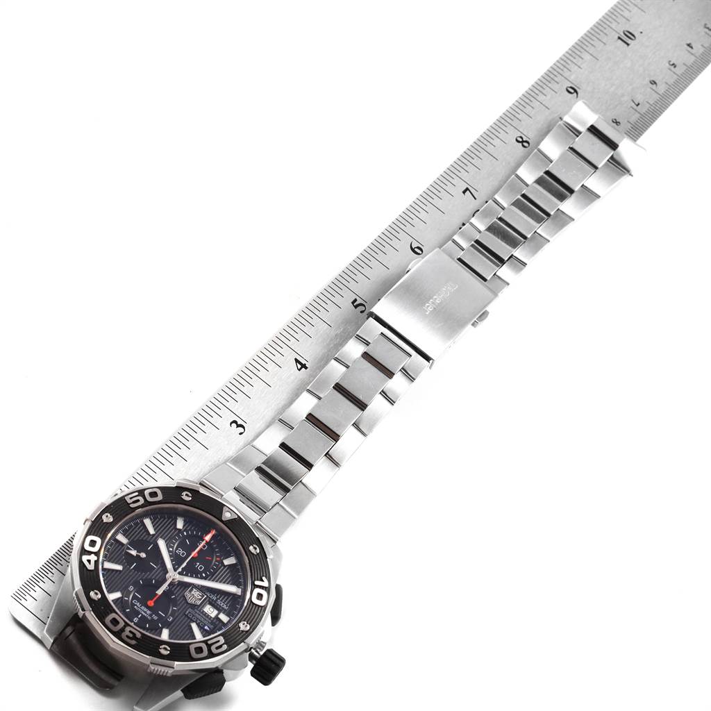 The image shows the Tag Heuer Aquaracer CAJ2112.BA0872 Men
s Stainless Steel Black Dial CAJ2112.BA0872 Men
s Stainless Steel Black Dial watch laid flat next to a ruler, displaying the watch face and stainless steel band.