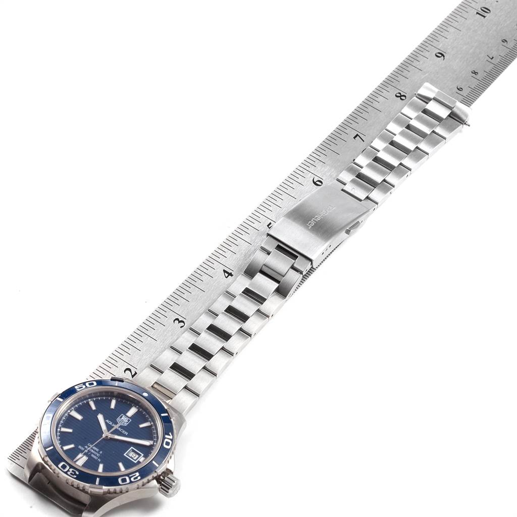 The image shows a Tag Heuer Aquaracer WAK2111.BA0830 Men's Stainless Steel Blue Dial WAK2111.BA0830 Men's Stainless Steel Blue Dial watch laid flat with a metal bracelet, positioned next to a ruler angled from the bottom left to top right.