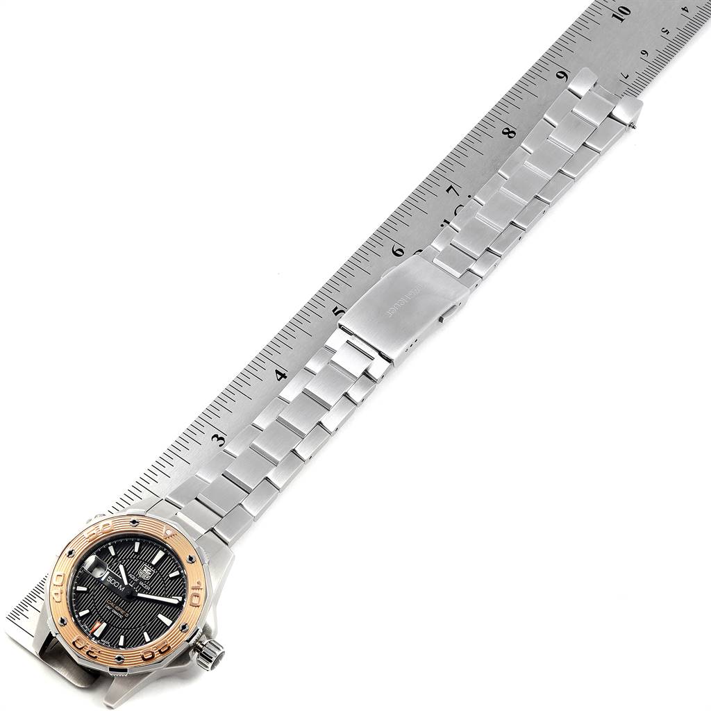 The image shows a Tag Heuer Aquaracer WAJ2150.BA0870 Men's Stainless Steel Black Dial WAJ2150.BA0870 Men's Stainless Steel Black Dial watch laid flat on a ruler, displaying its bracelet, clasp, and face.