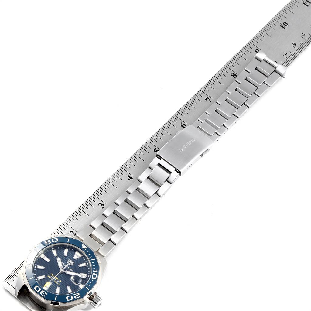 The image shows a Tag Heuer Aquaracer WAY201B Men's Stainless Steel Blue Dial WAY201B Men's Stainless Steel Blue Dial watch laid flat on a ruler, displaying the face, bezel, and metal bracelet.