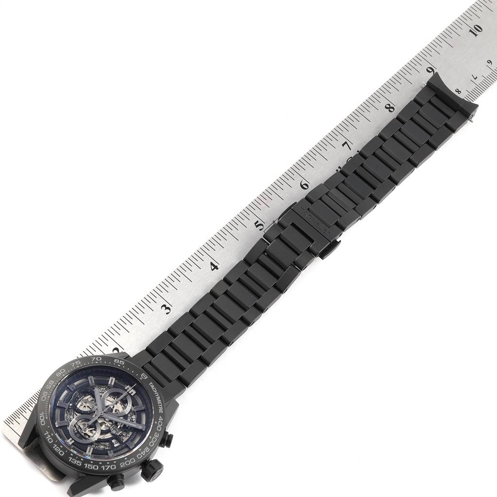 The image shows a Tag Heuer Carrera CAR2A91.BH0742 Men
s Stainless Steel Black Dial CAR2A91.BH0742 Men
s Stainless Steel Black Dial watch laid flat beside a ruler, showcasing the face and entire wristband.