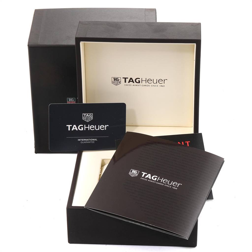 The image shows the packaging, guarantee card, and manual of the Tag Heuer Carrera CV2A84.FC6394 Men's Titanium Black Dial CV2A84.FC6394 Men's Titanium Black Dial model watch from a frontal angle.