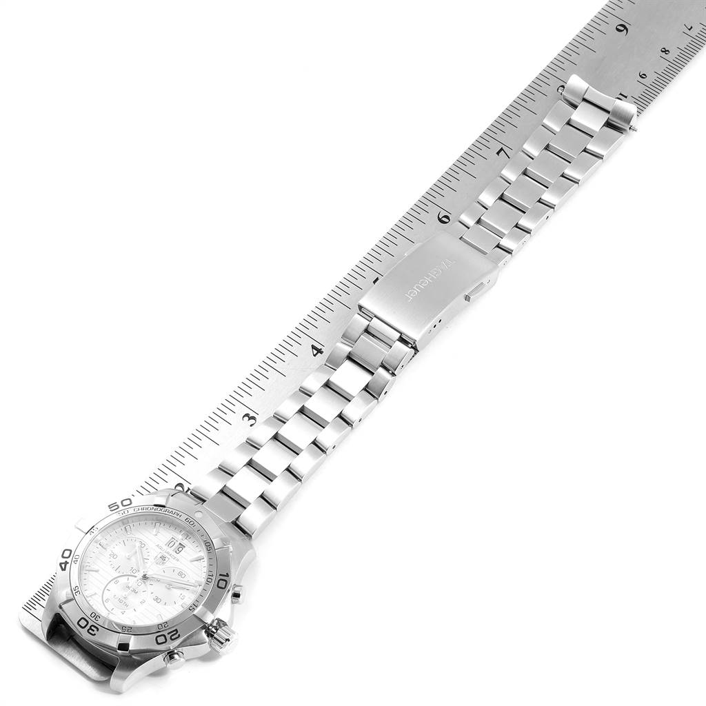 The image shows the Tag Heuer Aquaracer CAF101B.BA0821 Men's Stainless Steel Silver Dial CAF101B.BA0821 Men's Stainless Steel Silver Dial watch at an angle, with the focus on its stainless steel bracelet and clasp against a ruler.