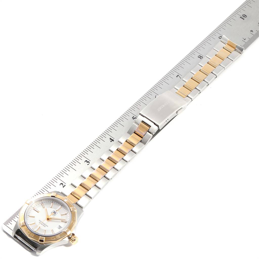 The image shows a Tag Heuer Aquaracer WAP1120.BB0832 Men's Steel and Gold (two tone) Silver Dial WAP1120.BB0832 Men's Steel and Gold (two tone) Silver Dial watch laid flat alongside a ruler, displaying its face, case, and two-tone bracelet.