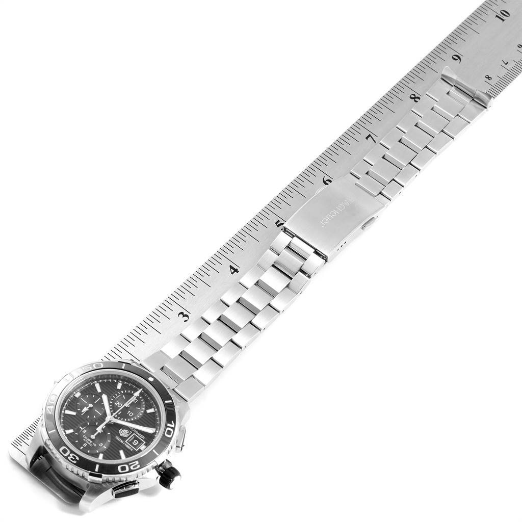 The image shows a side view of a Tag Heuer Aquaracer CAK2110.BA0833 Men's Stainless Steel Black Dial CAK2110.BA0833 Men's Stainless Steel Black Dial watch, with focus on its metal bracelet and clasp, measured against a ruler.