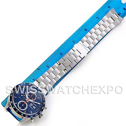 The image shows a Tag Heuer Carrera CV2015 Men's Stainless Steel Blue Dial CV2015 Men's Stainless Steel Blue Dial watch laid flat with a metal bracelet alongside a blue ruler, displaying its full length.