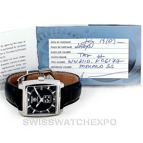 The image shows a front view of the Tag Heuer Monaco WW2110 Men's Stainless Steel Black Dial WW2110 Men's Stainless Steel Black Dial watch with a black leather strap and includes the service card behind it.