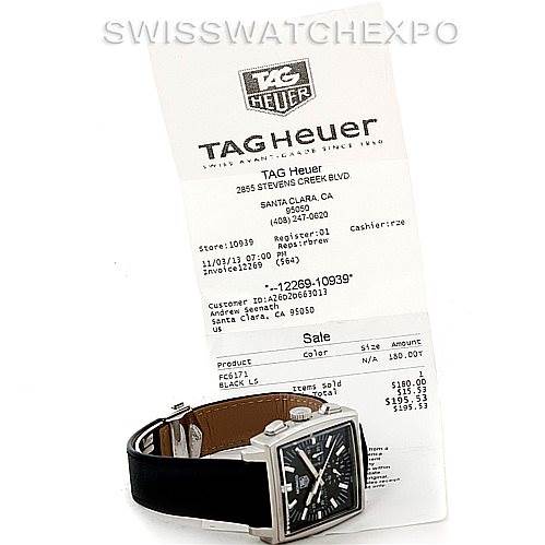 The image shows a Tag Heuer Monaco CW2111 Men
s Stainless Steel Black Dial CW2111 Men
s Stainless Steel Black Dial watch at an angle displaying its face and part of the strap, alongside a receipt.