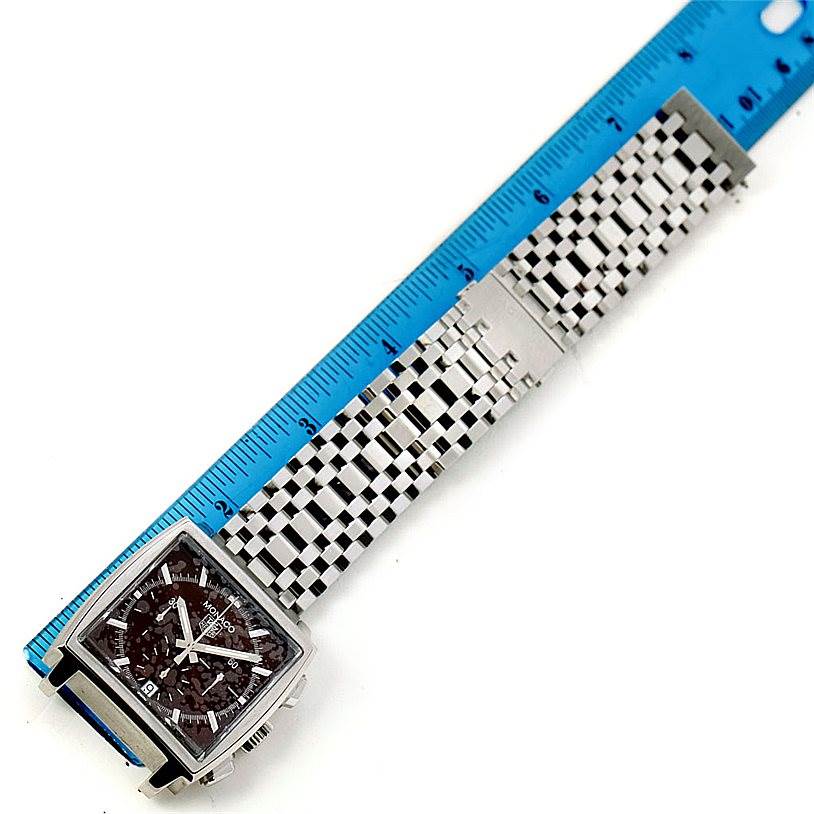 The image shows a Tag Heuer Monaco CW2114 Men's Stainless Steel Brown Dial CW2114 Men's Stainless Steel Brown Dial watch laid out flat with a blue ruler for measurement; the face and metal bracelet are visible.