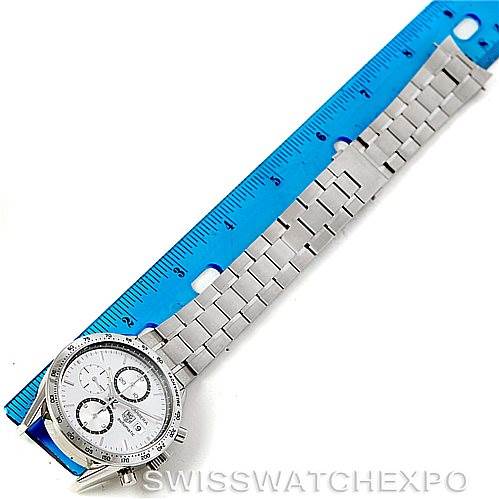 The image shows a Tag Heuer Carrera CV2017 Men's Stainless Steel Silver Dial CV2017 Men's Stainless Steel Silver Dial watch positioned next to a blue ruler, highlighting the bracelet and partially the watch face.