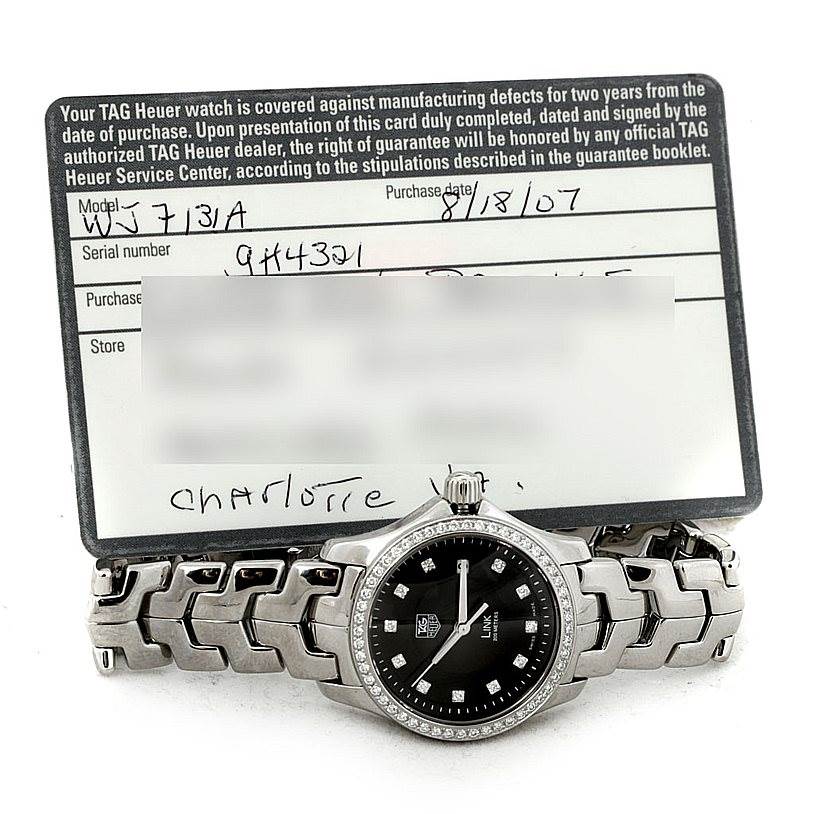 The image shows a Tag Heuer Link WJF131A Women's Stainless Steel Black Dial WJF131A Women's Stainless Steel Black Dial model watch, laid flat with its warranty card positioned behind it.