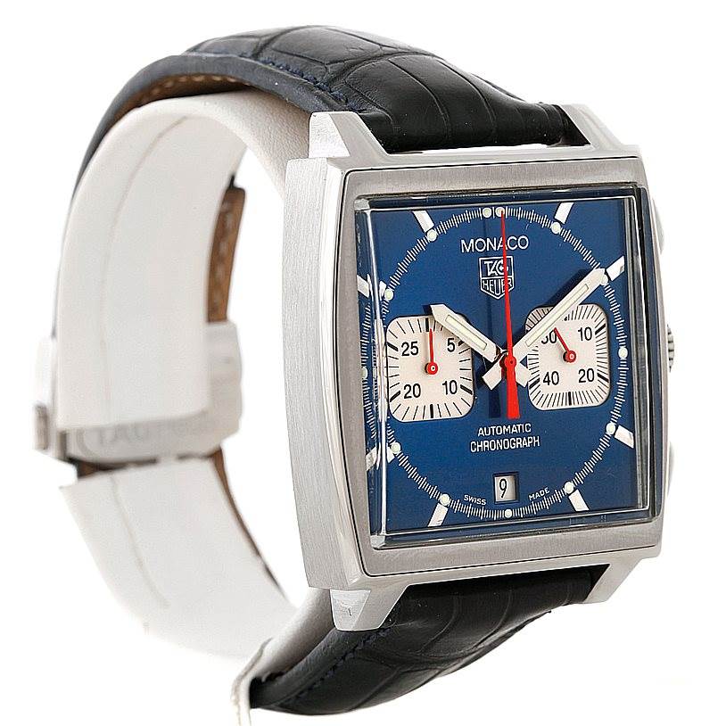 The image displays a Tag Heuer Monaco CW2113 Men
s Stainless Steel Blue Dial CW2113 Men
s Stainless Steel Blue Dial watch at an angle showcasing its square dial, blue face, chronograph subdials, and leather strap.