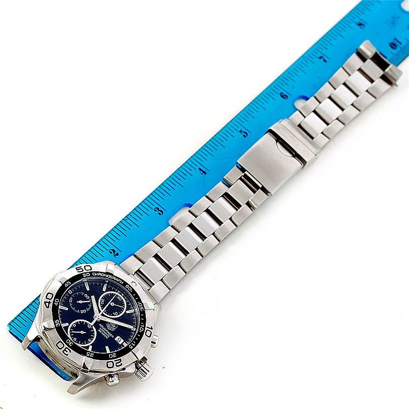 The Tag Heuer Aquaracer CAF2110 Men's Stainless Steel Black Dial CAF2110 Men's Stainless Steel Black Dial watch is displayed from a diagonal angle, featuring its full face, bracelet, and clasp alongside a ruler for scale.