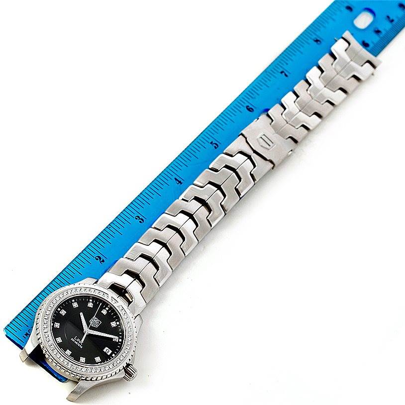 The image shows a Tag Heuer Link WJ1117 Men's Stainless Steel  WJ1117 Men's Stainless Steel  model watch laid flat alongside a blue ruler, displaying the watch face and stainless steel bracelet.