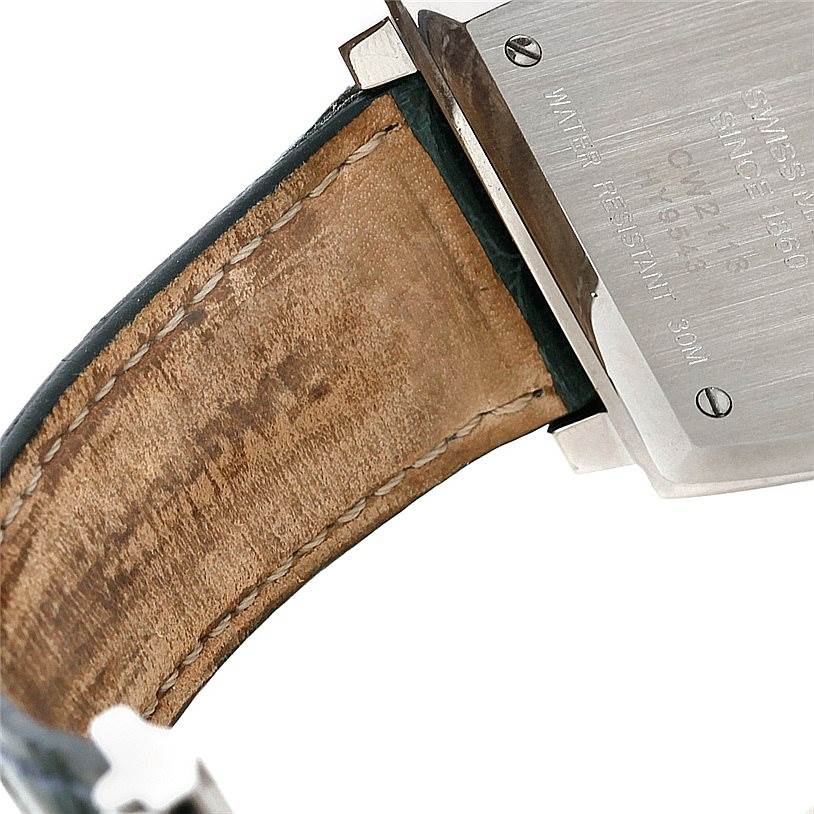 The image shows the backside of a Tag Heuer Monaco CW2113 Men's Stainless Steel Blue Dial CW2113 Men's Stainless Steel Blue Dial watch, displaying part of the leather strap and the watch case back with engravings.