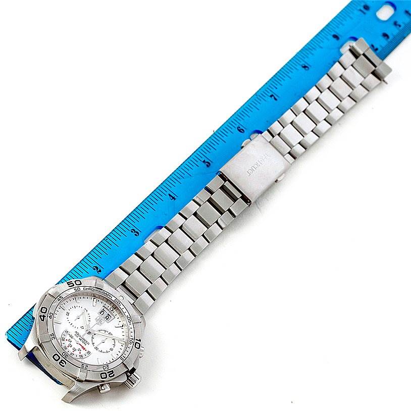 The Tag Heuer Aquaracer CAF101B Men
s Stainless Steel Silver Dial CAF101B Men
s Stainless Steel Silver Dial watch is shown from a top-down angle, displaying the face, bezel, and stainless steel bracelet alongside a blue ruler.