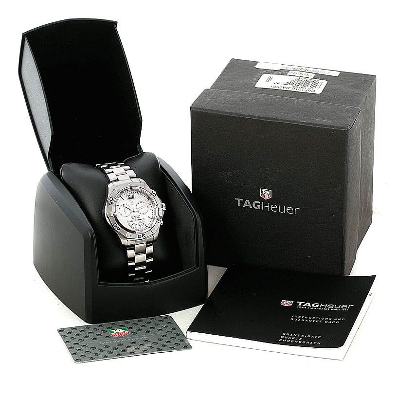 The image shows a Tag Heuer Aquaracer CAF101B Men
s Stainless Steel Silver Dial CAF101B Men
s Stainless Steel Silver Dial watch in its opened case, alongside its box, warranty card, and instruction manual.
