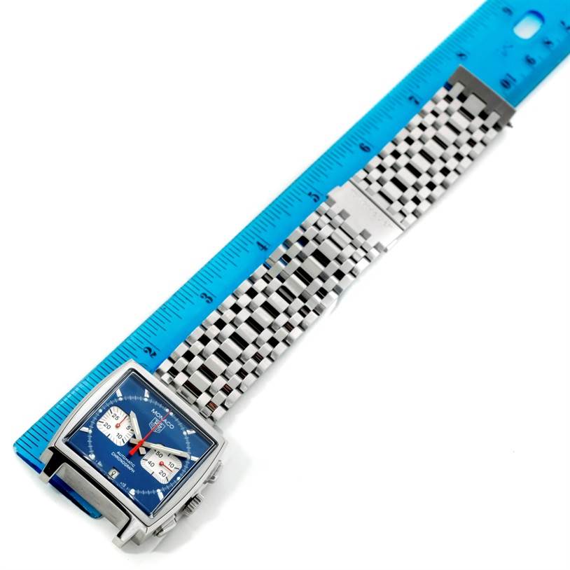 The image shows a top-down view of the Tag Heuer Monaco CW2113 Men's Stainless Steel Blue Dial CW2113 Men's Stainless Steel Blue Dial watch, with a blue dial and stainless steel bracelet, next to a ruler.