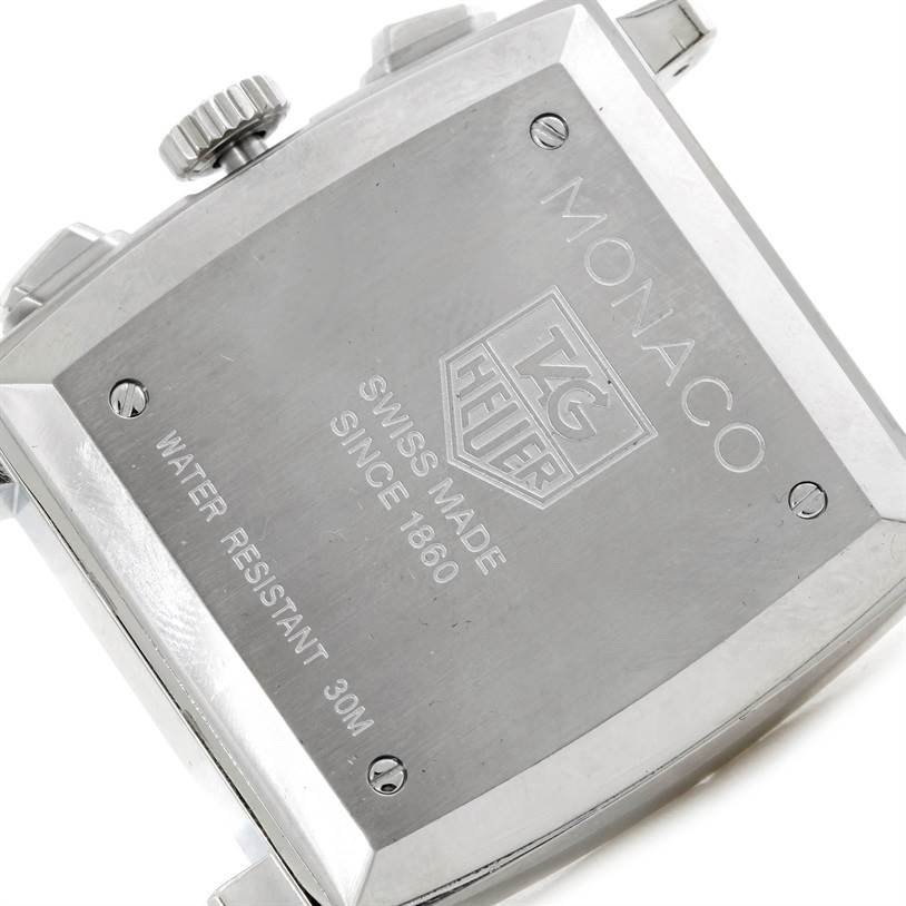 The image shows the back case of a Tag Heuer Monaco CW2113 Men's Stainless Steel Blue Dial CW2113 Men's Stainless Steel Blue Dial watch, displaying its inscriptions and screws.