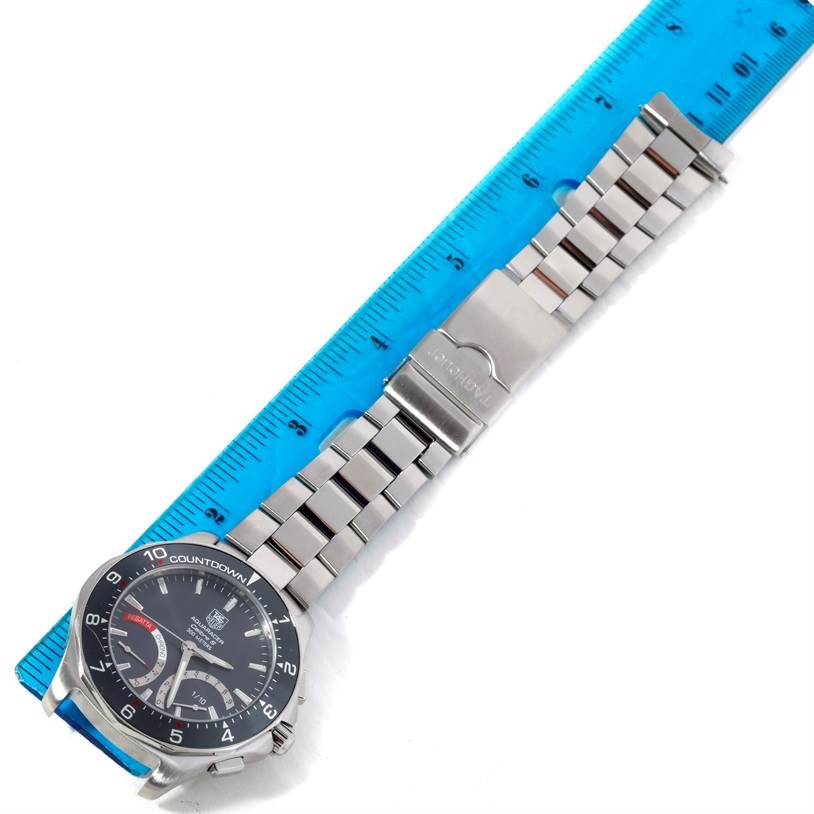 The image shows a Tag Heuer Aquaracer CAF7111.BA0803 Men's Stainless Steel Black Dial CAF7111.BA0803 Men's Stainless Steel Black Dial watch laid flat next to a ruler, displaying its band, clasp, and face.