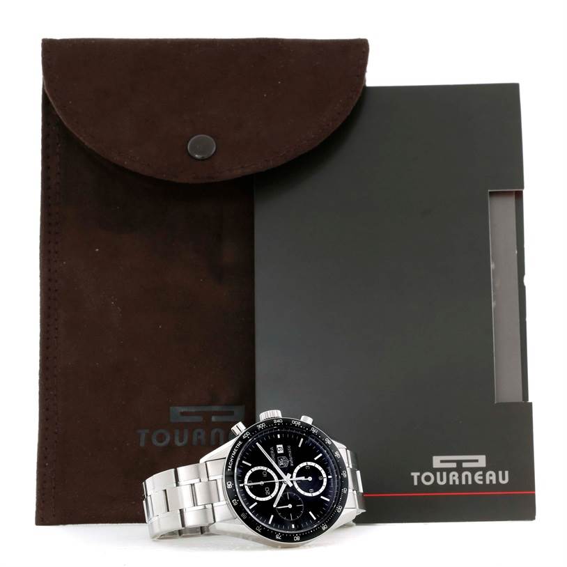 The image shows a Tag Heuer Carrera CV2010-3 Men's Stainless Steel Black Dial CV2010-3 Men's Stainless Steel Black Dial watch placed in front of a brown suede pouch and a black case marked with the "Tourneau" logo.