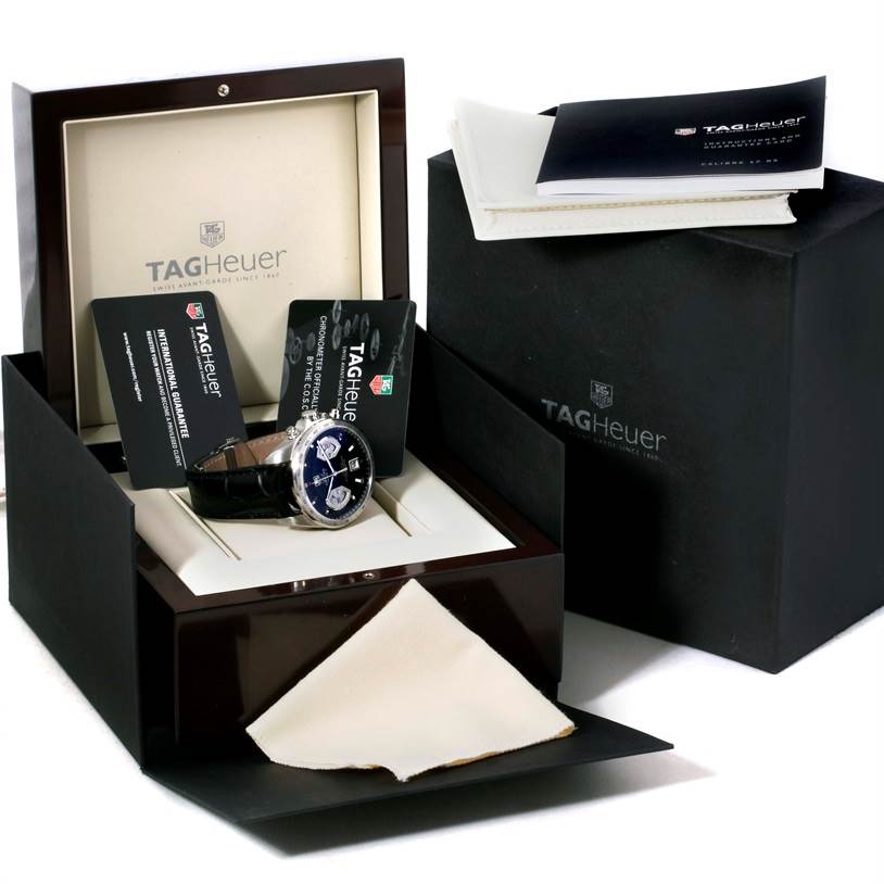 The image shows a Tag Heuer Carrera CAV511A.FC6225 Men's Stainless Steel Black Dial CAV511A.FC6225 Men's Stainless Steel Black Dial watch in its packaging with accompanying booklets and warranty cards.