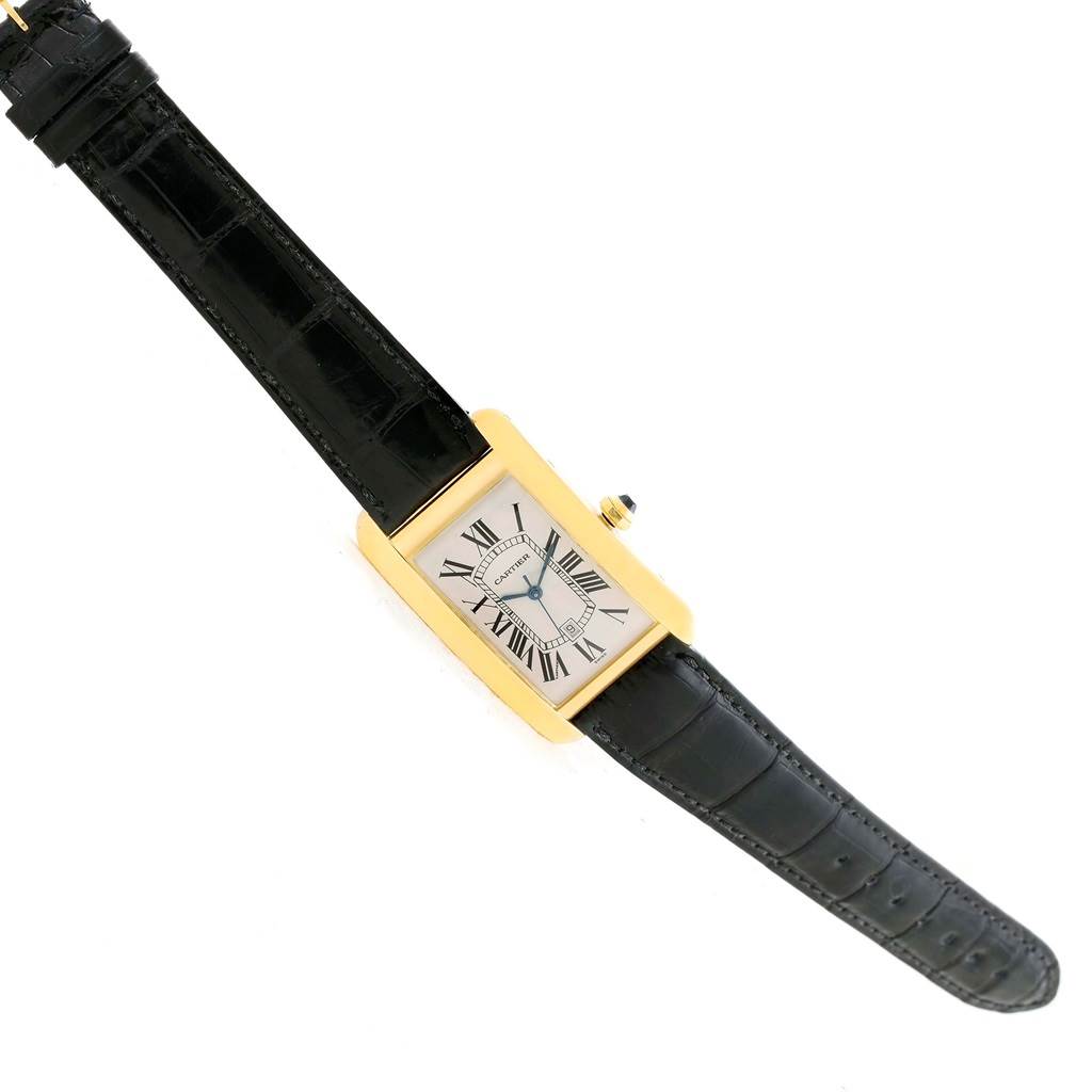 This image shows the Cartier Tank Americaine W2603156 Men's Yellow Gold Silver Dial W2603156 Men's Yellow Gold Silver Dial watch from a top-down angle, displaying its rectangular face, Roman numerals, and black leather strap.