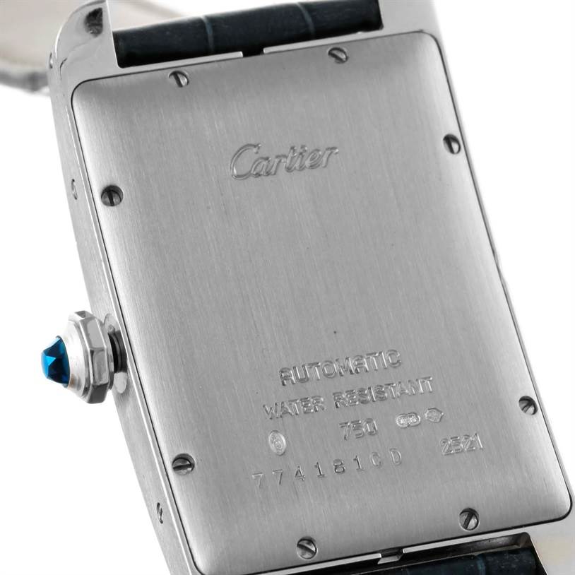 The image shows the backside of the Cartier Tank Américaine watch, highlighting its engravings and a blue cabochon crown.