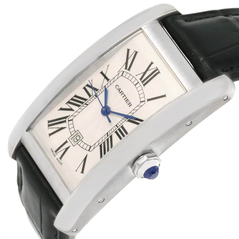 The image shows a close-up angle of a Cartier Tank Americaine W2603256 Men's White Gold Silver Dial W2603256 Men's White Gold Silver Dial watch, highlighting the dial, crown, and leather strap.